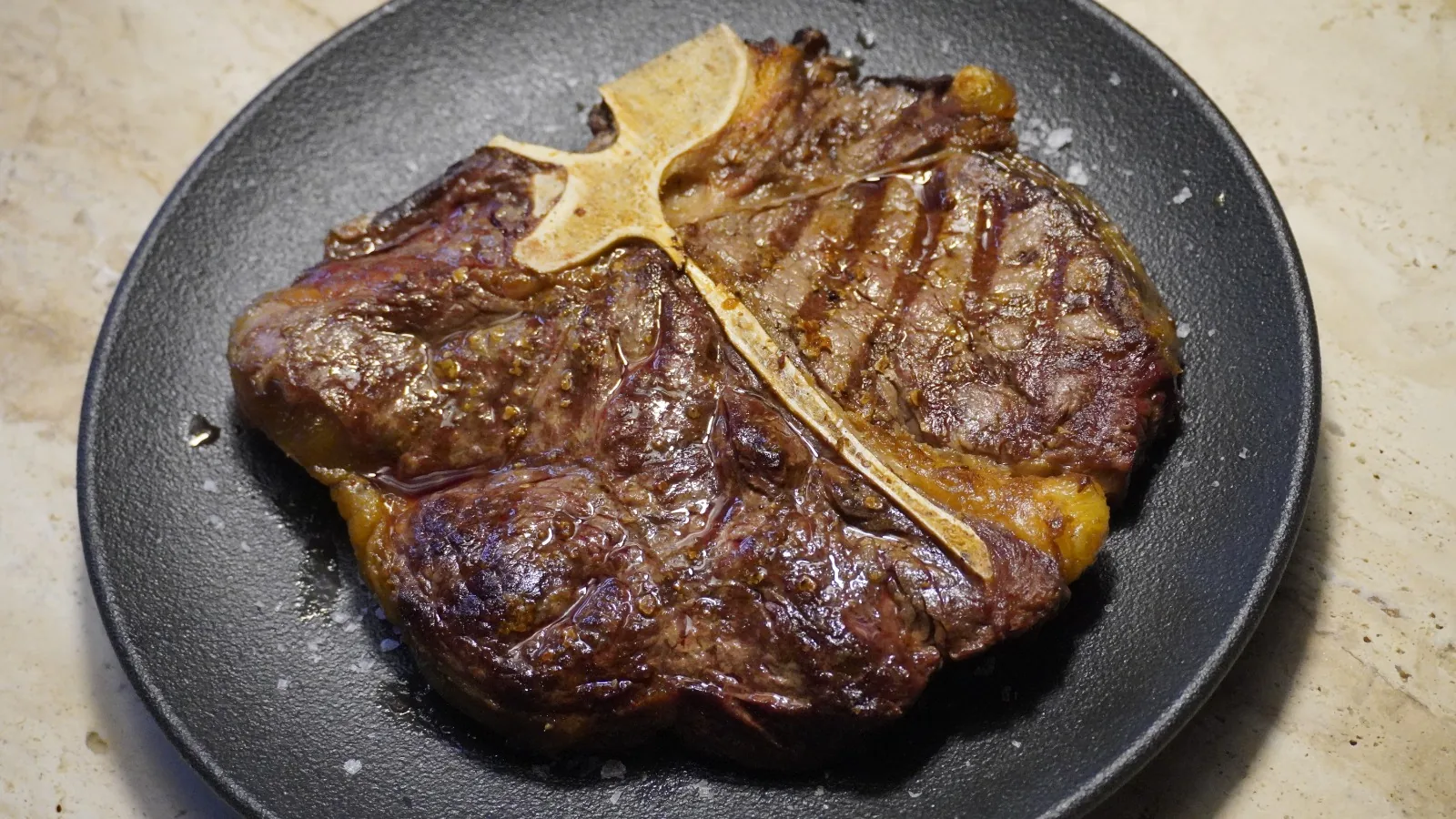 Un T-bone de Madero asado a la brasa, servido en plato